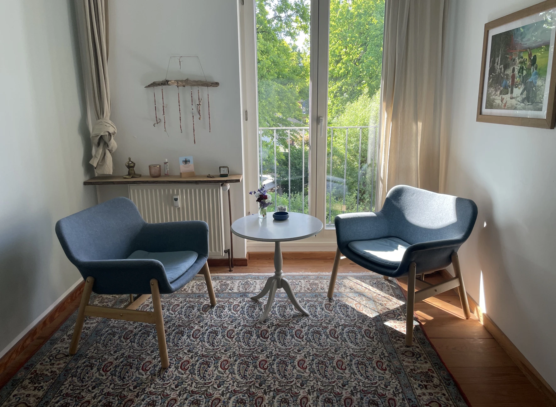 Zwei blaue Sessel und ein runder Tisch im Praxisraum von Nina Kranz – ruhiger Ort für therapeutische Begleitung.